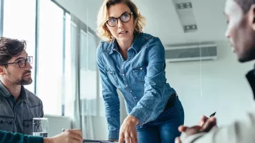 Una professionista donna presenta ai propri colleghi un progetto in un ufficio moderno