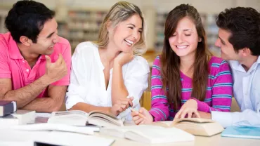 Gruppo di persone che studiano insieme in biblioteca.