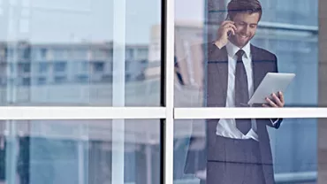 Persona in ufficio con tablet e telefono.