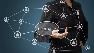 Persona in abito nero con diagramma di leadership interconnesso.