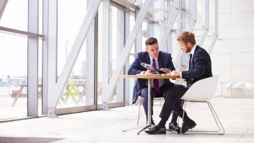 Due persone in abiti formali discutono in un ufficio moderno.