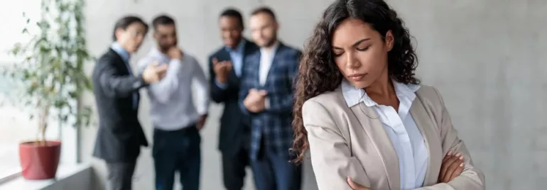 Episodio di mobbing sul lavoro con la donna in primo piano discriminata dai colleghi