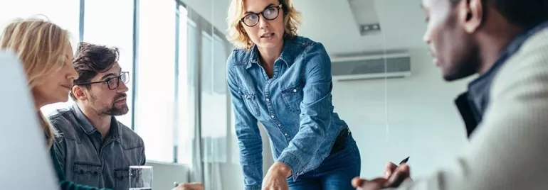 Una professionista donna presenta ai propri colleghi un progetto in un ufficio moderno